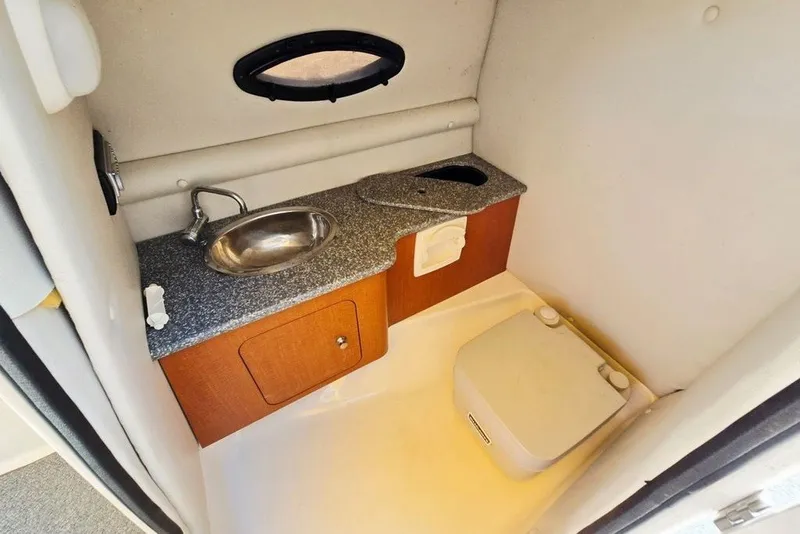 Slide: The Image of 2005 Chaparral Sunesta 254 boat bathroom with sink, countertop, and portable toilet. - 24