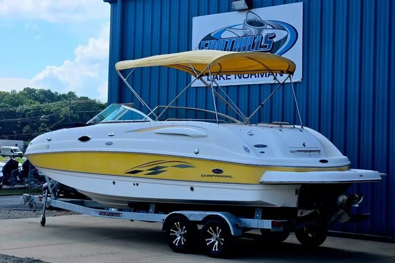 Slide: The Image of 2005 Chaparral Sunesta 254 boat with yellow accents on a trailer, parked outside. - 32