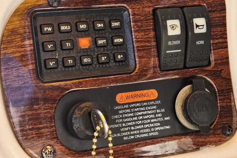 Slide: The Image of Control panel of a 2005 Chaparral Sunesta 254 boat with warning label and switches. - 26