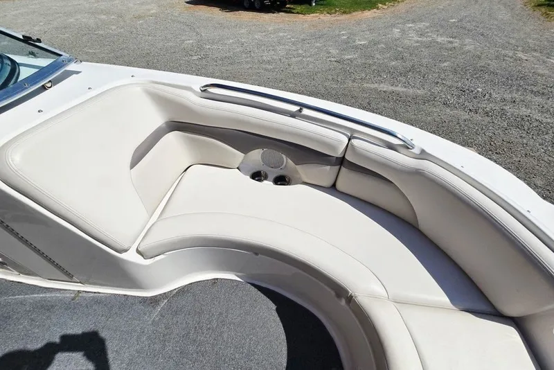 Slide: The Image of 2005 Chaparral Sunesta 254 boat interior with white cushioned seating and cup holders. - 25