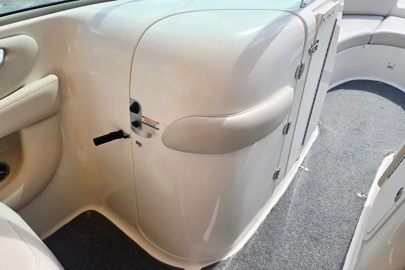 Slide: The Image of 2005 Chaparral Sunesta 254 boat interior with white seating and carpeted flooring. - 14