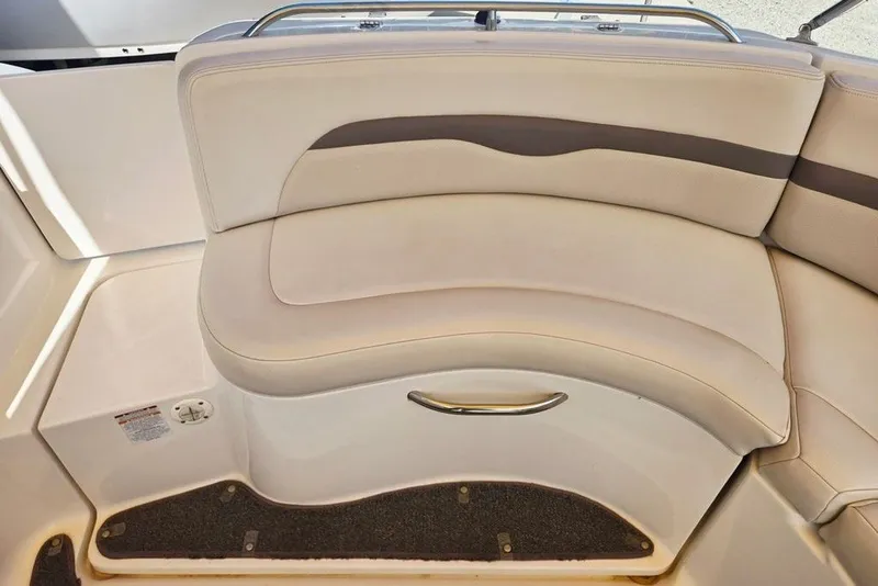 Slide: The Image of 2005 Chaparral Sunesta 254 boat interior seating with beige upholstery and storage compartment. - 3