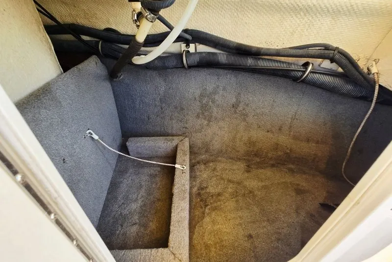 Slide: The Image of Interior storage compartment of 2005 Chaparral Sunesta 254 boat, featuring carpeted flooring and wiring. - 18