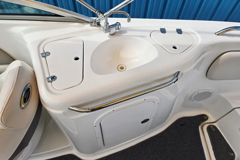 Slide: The Image of 2005 Chaparral Sunesta 254 boat sink and storage area with chrome fixtures. - 9