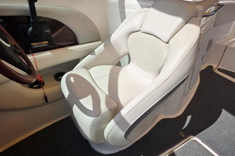 Slide: The Image of 2005 Chaparral Sunesta 254 boat interior with plush white captain's seat and steering wheel. - 20