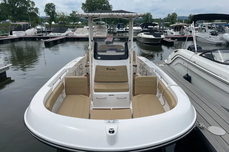 Slide: The Image of 2024 Trophy CC22 boat docked at marina, featuring spacious seating and sleek design. - 1