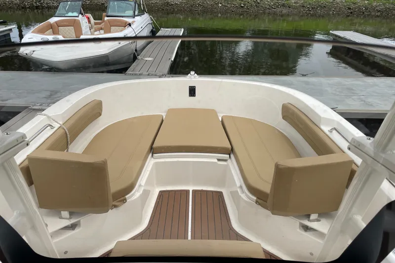 Slide: The Image of 2024 Trophy CC22 boat interior with tan seating, docked by the water. - 6