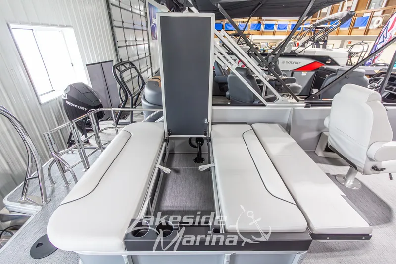 Slide: The Image of 2026 Godfrey Monaco 235 SFLC boat interior with seating and Mercury engine in showroom. - 25