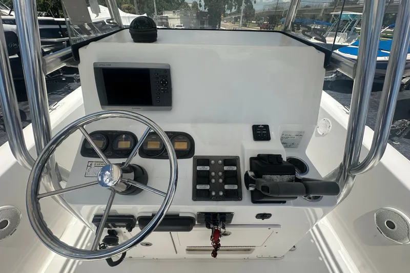 Slide: The Image of 2005 Cobia 254 Center Console boat dashboard with steering wheel and controls. - 17