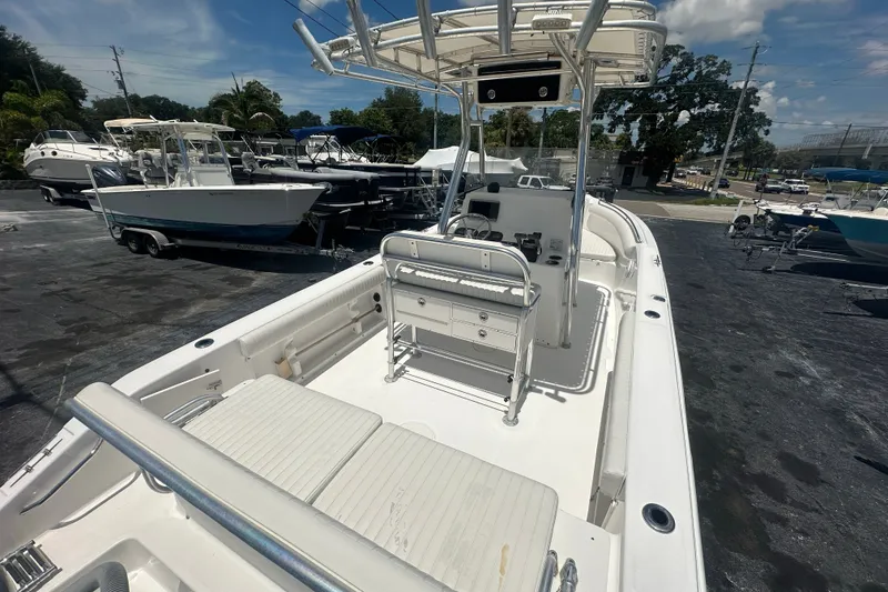 Slide: The Image of 2005 Cobia 254 Center Console boat with spacious deck and seating, parked outdoors. - 9