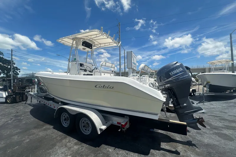Slide: The Image of 2005 Cobia 254 Center Console boat on trailer with Yamaha engine under clear blue sky. - 2
