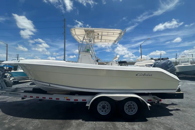 Slide: The Image of 2005 Cobia 254 Center Console boat on trailer under clear blue sky. - 1