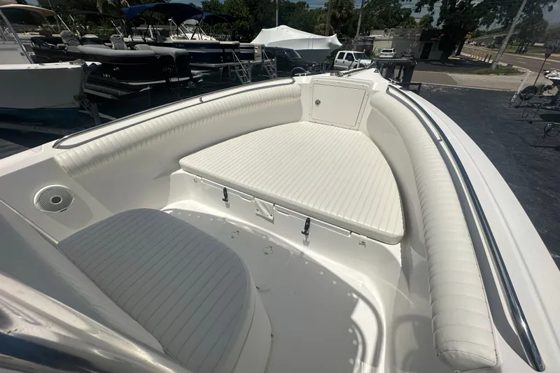 Slide: The Image of 2005 Cobia 254 Center Console boat with white cushioned seating and storage compartment. - 23