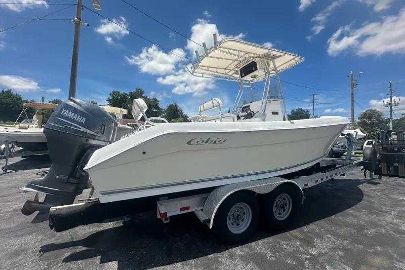 Slide: The Image of 2005 Cobia 254 Center Console boat on trailer with Yamaha outboard motor under clear sky. - 6