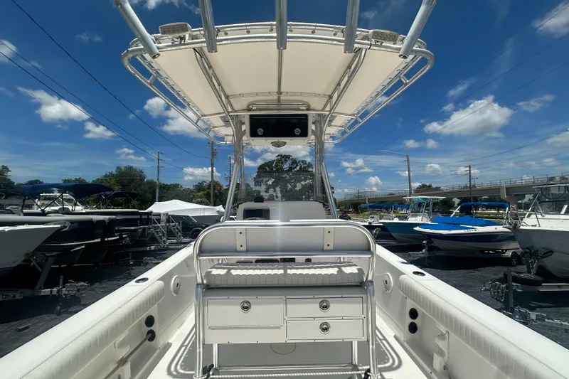 Slide: The Image of 2005 Cobia 254 Center Console boat with T-top, docked under a clear blue sky. - 10