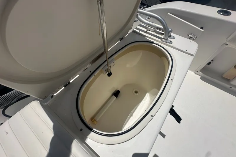 Slide: The Image of An open storage compartment on a 2005 Cobia 254 Center Console boat. - 12