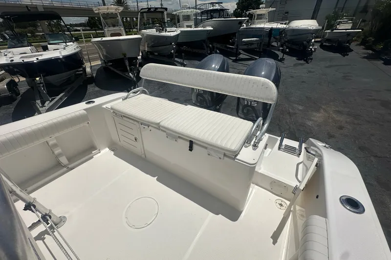 Slide: The Image of 2005 Cobia 254 Center Console boat with dual Yamaha 115 engines, docked among other boats. - 13