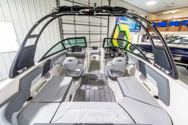 Slide: The Image of 2026 Chaparral 23 SSi boat interior with sleek seating and modern dashboard in showroom. - 5