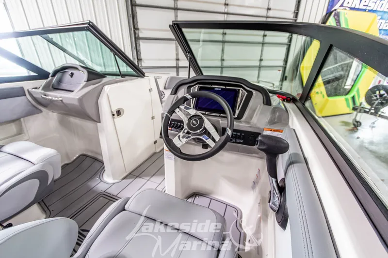 Slide: The Image of Interior view of 2026 Chaparral 23 SSi boat cockpit with steering wheel and controls. - 12