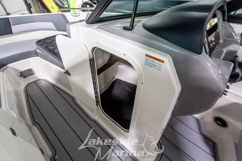 Slide: The Image of 2026 Chaparral 23 SSi boat interior with open storage compartment and sleek seating. - 18