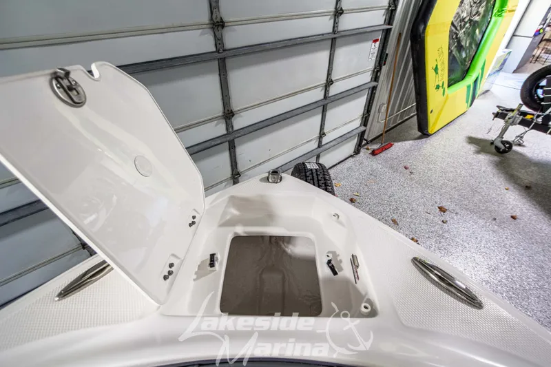 Slide: The Image of 2026 Chaparral 23 SSi boat storage compartment open in a garage setting. - 24