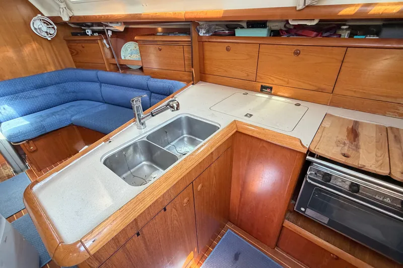 Slide: The Image of Interior of 2003 Jeanneau Sun Fast 37 yacht with wooden cabinetry and compact kitchen area. - 23