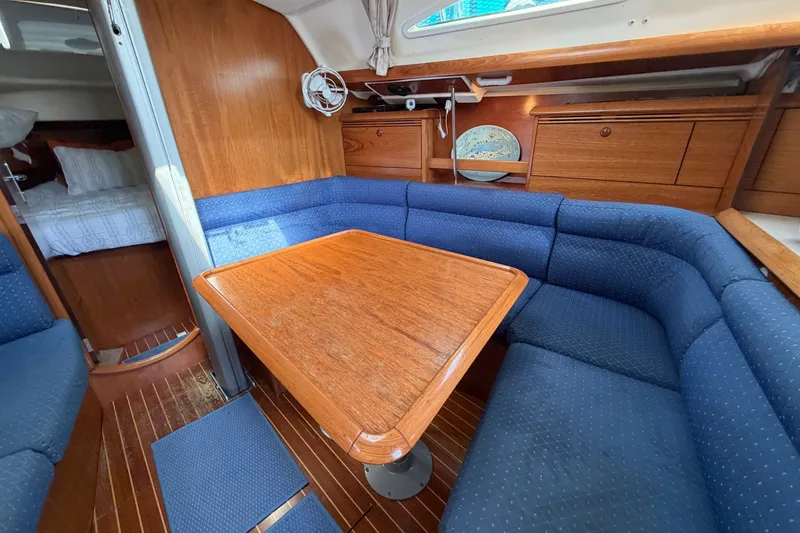 Slide: The Image of Cozy interior of 2003 Jeanneau Sun Fast 37 sailboat with blue seating and wooden table. - 21
