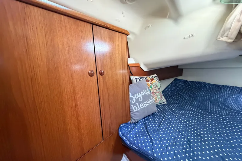 Slide: The Image of Cozy cabin interior of 2003 Jeanneau Sun Fast 37 with wooden cabinet and polka dot bedding. - 35