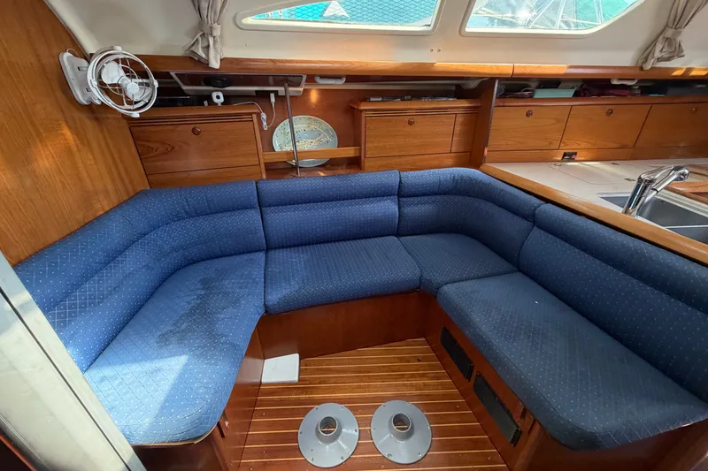 Slide: The Image of Interior of 2003 Jeanneau Sun Fast 37 yacht with blue cushioned seating and wooden cabinetry. - 20