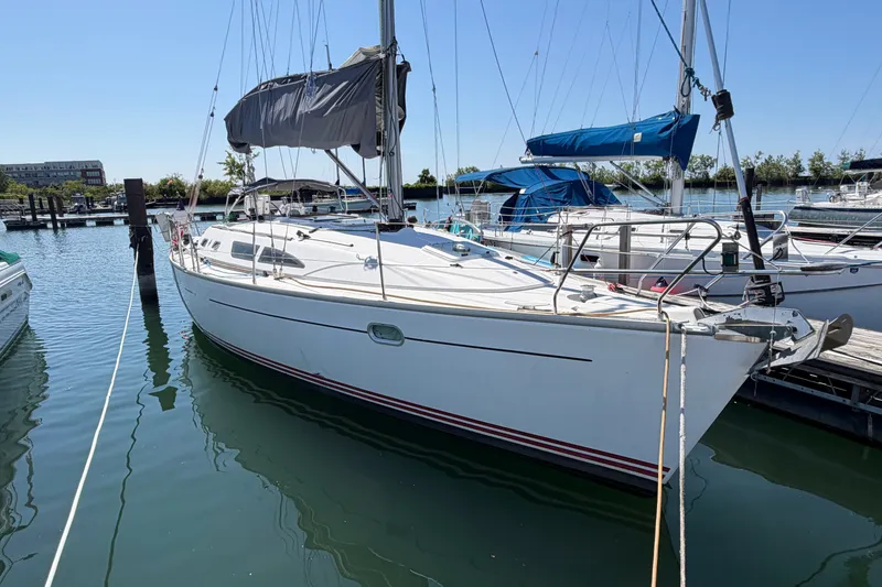 Slide: The Image of 2003 Jeanneau Sun Fast 37 sailboat docked in a marina under clear blue skies. - 2
