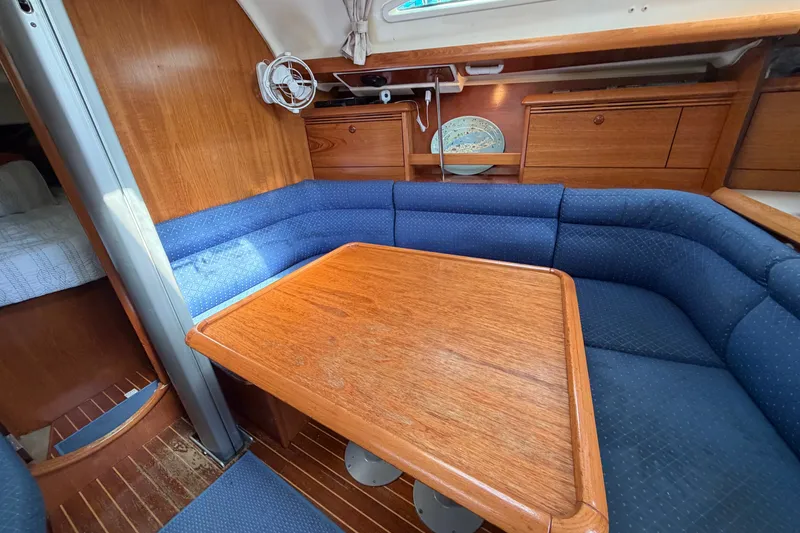 Slide: The Image of Interior of 2003 Jeanneau Sun Fast 37 yacht with wooden table and blue seating. - 22
