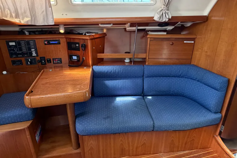 Slide: The Image of Interior of 2003 Jeanneau Sun Fast 37 sailboat with blue cushioned seating and wooden table. - 19