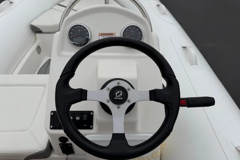 Slide: The Image of Steering wheel of 2024 Zodiac Yachtline 490 boat, featuring modern dashboard controls. - 10