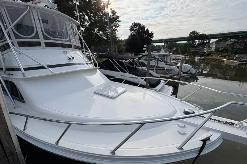 Slide: The Image of 2001 Blackfin 33 Flybridge boat docked at a marina under a cloudy sky. - 1