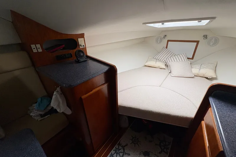 Slide: The Image of Cozy cabin interior of 2001 Blackfin 33 Flybridge with bed, pillows, and wooden cabinetry. - 15