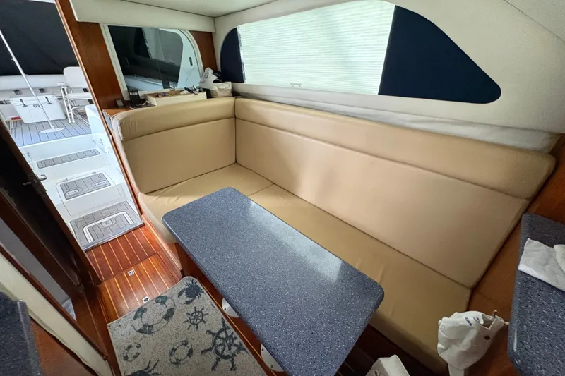 Slide: The Image of Interior of 2001 Blackfin 33 Flybridge with beige seating and blue table. - 16
