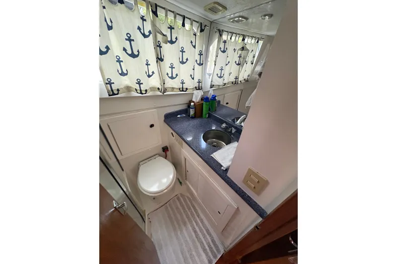 Slide: The Image of Bathroom interior of 2001 Blackfin 33 Flybridge with nautical-themed curtains. - 18