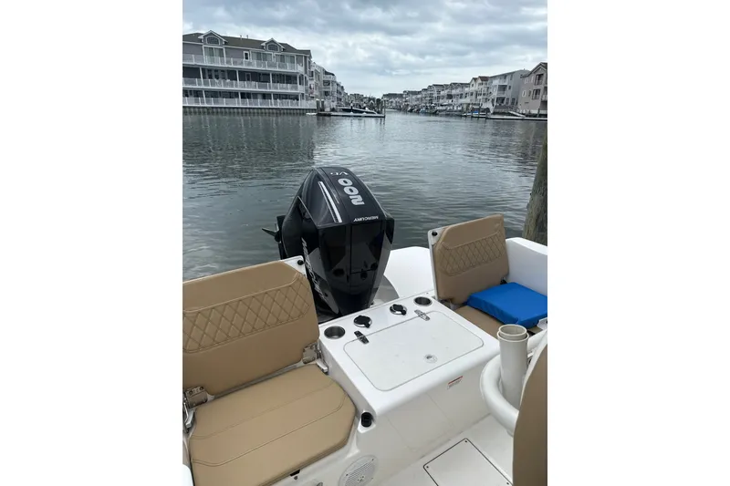 Slide: The Image of 2024 Trophy CC22 boat with Mercury outboard motor, docked in a scenic waterfront area. - 7