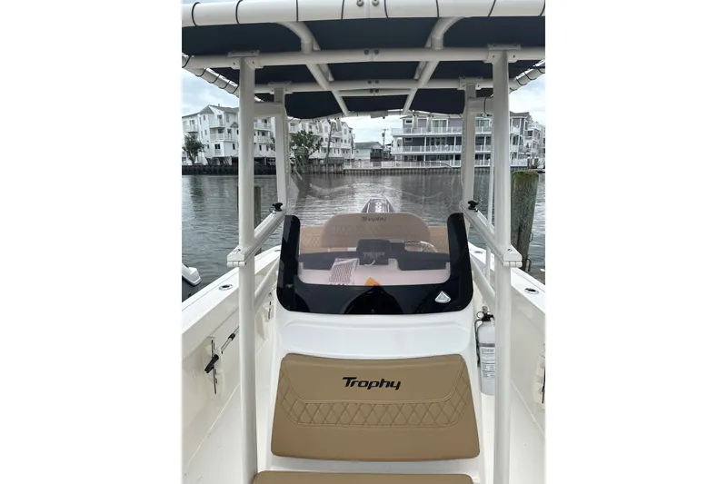 Slide: The Image of 2024 Trophy CC22 boat interior with tan seating, docked near waterfront buildings. - 3