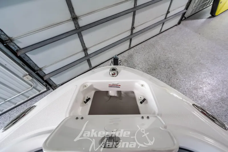 Slide: The Image of 2026 Chaparral 21 SSi boat interior, featuring storage compartment and sleek design in a garage setting. - 24