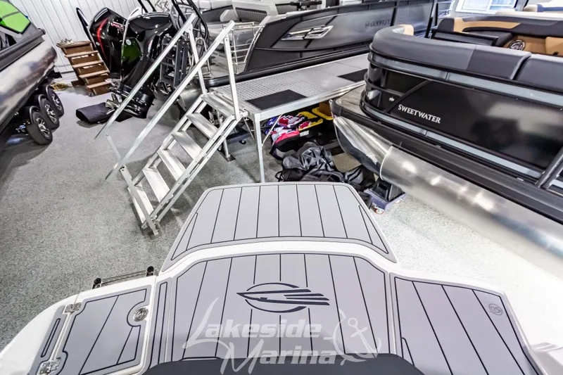 Slide: The Image of 2026 Chaparral 21 SSi boat in showroom with Sweetwater pontoon, Lakeside Marina branding. - 1