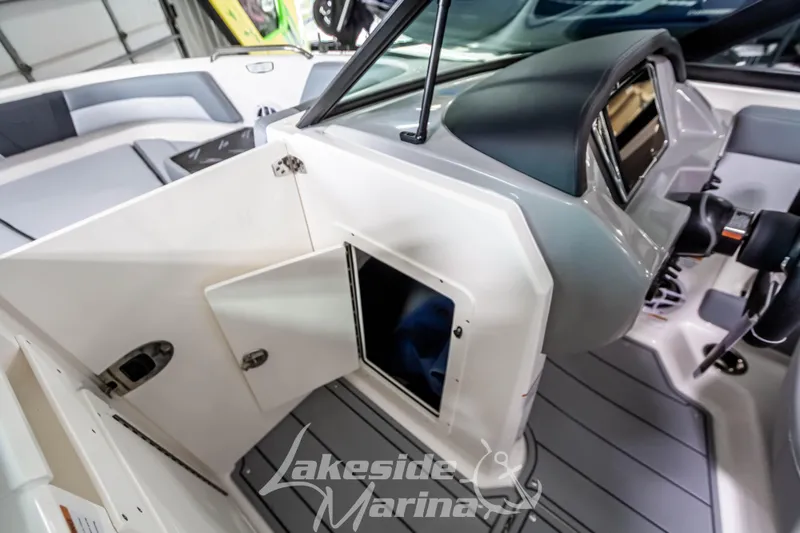 Slide: The Image of 2026 Chaparral 21 SSi boat interior with open storage compartment and modern dashboard. - 19