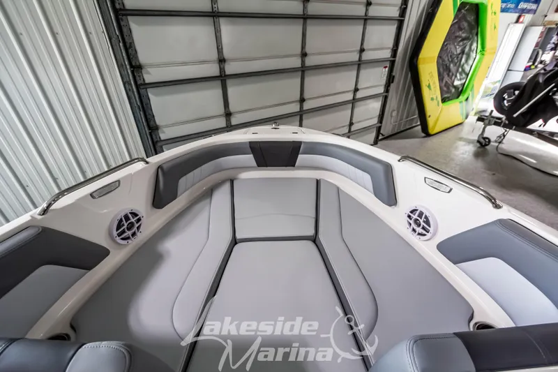 Slide: The Image of 2026 Chaparral 21 SSi boat interior with gray seating, in a marina garage. - 22