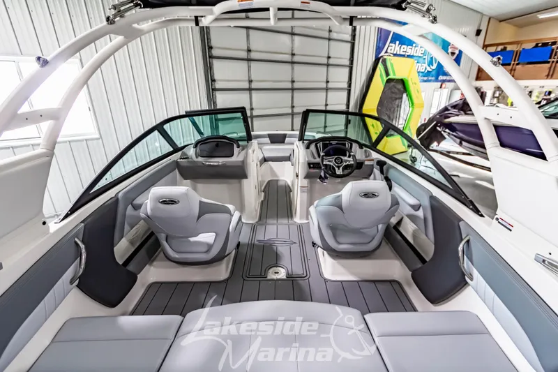Slide: The Image of 2026 Chaparral 21 SSi boat interior with modern seating and steering wheel in a marina setting. - 5