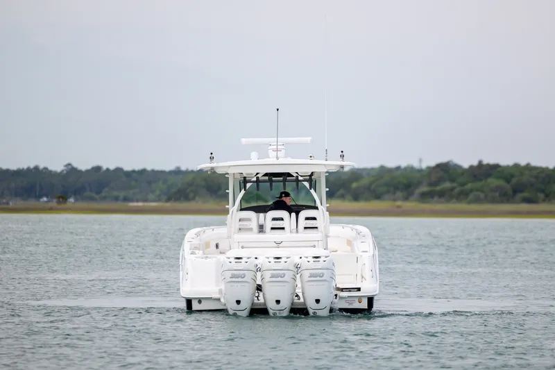 Slide: The Image of 2017 Boston Whaler 370 Outrage boat on water, rear view with triple engines. - 4