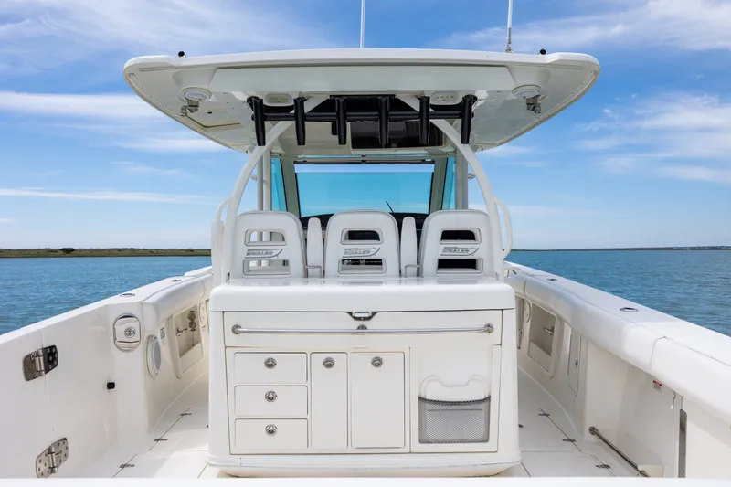 Slide: The Image of 2017 Boston Whaler 370 Outrage boat interior with seating and storage, on calm water. - 23