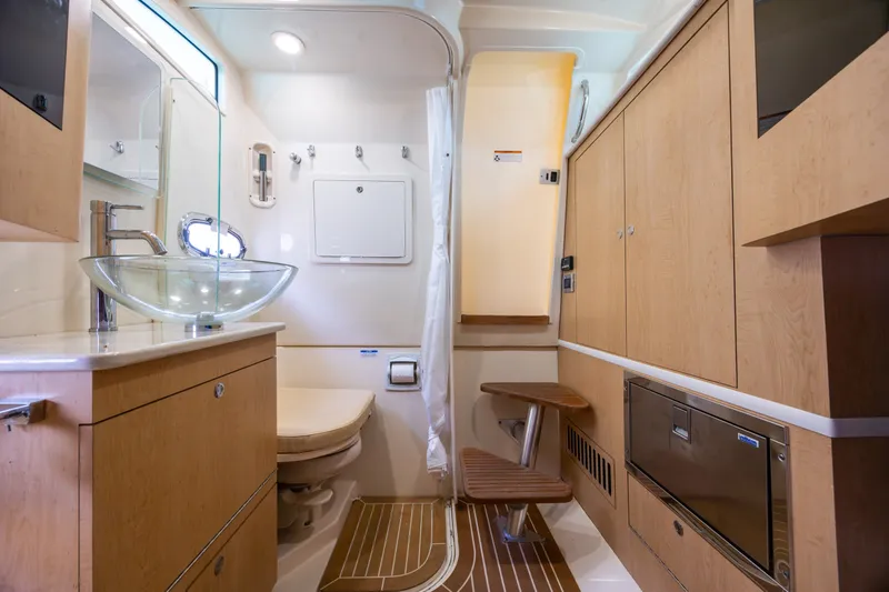 Slide: The Image of Luxurious bathroom interior of 2017 Boston Whaler 370 Outrage with modern fixtures and wood accents. - 48
