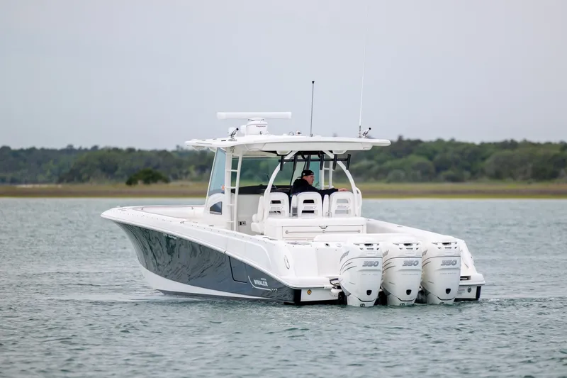 Slide: The Image of 2017 Boston Whaler 370 Outrage boat with triple engines cruising on calm water. - 3