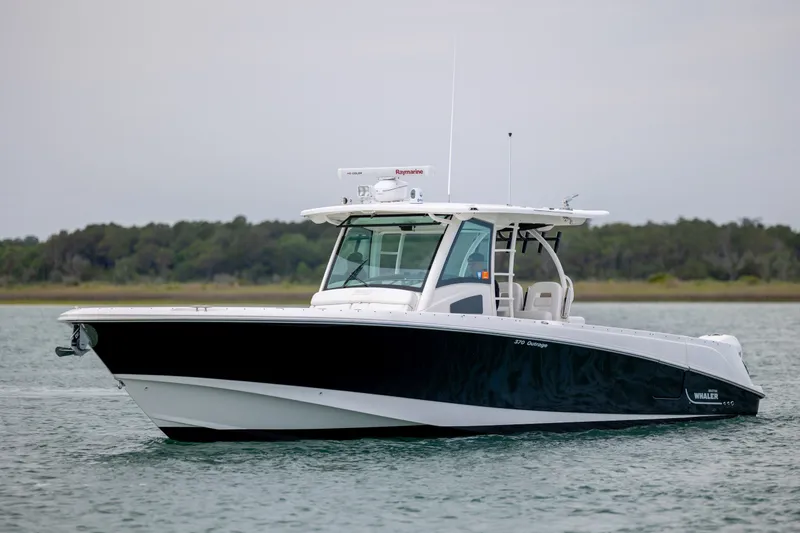 Slide: The Image of 2017 Boston Whaler 370 Outrage boat on calm water, showcasing sleek design and modern features. - 13