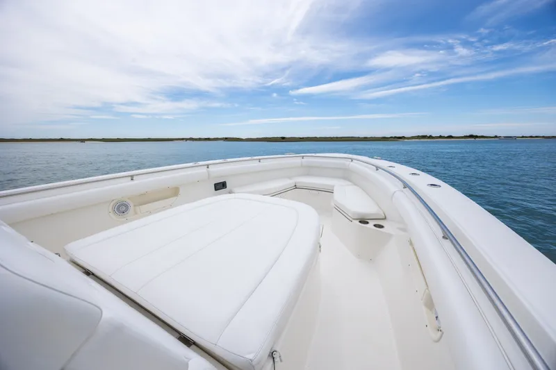 Slide: The Image of 2017 Boston Whaler 370 Outrage boat interior with white seating, on calm water. - 36